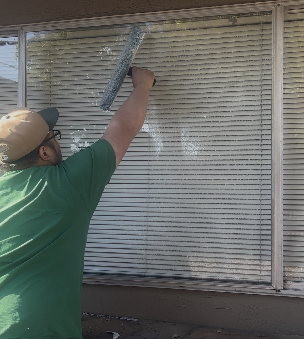 Weldi's employee cleaning a window